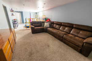 Living room with a textured ceiling and carpet flooring