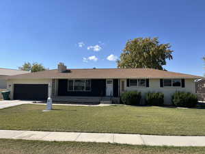 Ranch-style house with a front yard and a garage