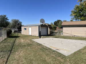 View of outbuilding featuring a garage and a lawn