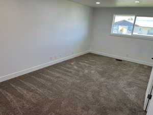 Unfurnished room with dark colored carpet