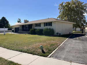 Ranch-style house featuring a front yard and a garage