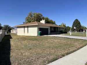 View of front facade featuring a front yard and a garage