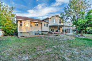 Back of property featuring a storage unit, a patio area, and a yard