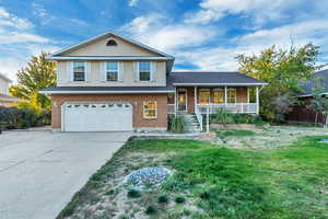 Split level home featuring a front yard, a porch, and a garage