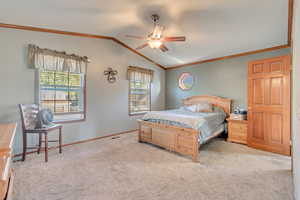 Bedroom with crown molding, vaulted ceiling, light carpet, and ceiling fan