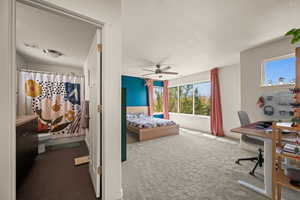 Bedroom featuring carpet flooring, multiple windows, and ceiling fan