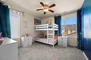 Carpeted bedroom featuring ceiling fan