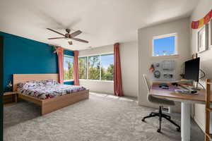 Carpeted bedroom featuring ceiling fan