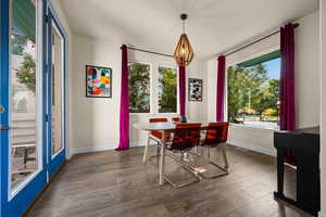 Dining space with a notable chandelier and dark hardwood / wood-style floors