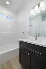 Bathroom featuring wood-type flooring, bathing tub / shower combination, and vanity