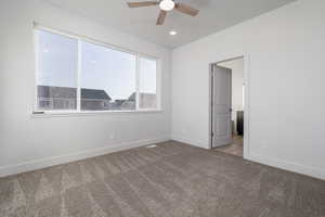 Carpeted empty room featuring ceiling fan