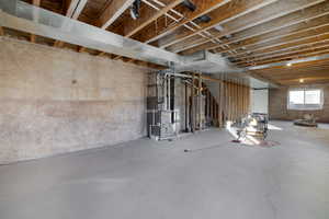 Basement featuring heating unit and water heater