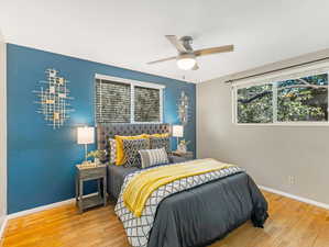 Bedroom featuring multiple windows, ceiling fan, and hardwood / wood-style flooring