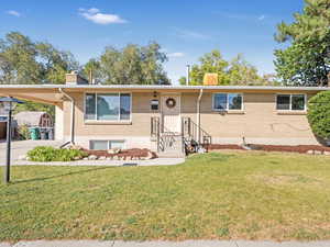 View of front of home featuring a front lawn and a carport