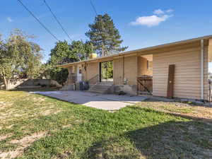 Back of property featuring central air condition unit and a yard