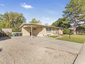 View of front of home with a front yard and a shed