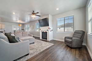 Living room with plenty of natural light, dark hardwood / wood-style floors, and a textured ceiling