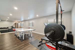 Exercise room with dark hardwood / wood-style floors and a textured ceiling