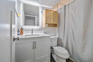 Bathroom with vanity, toilet, and a textured ceiling