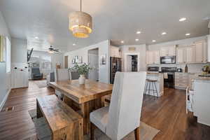 Dining room with a textured ceiling, ceiling fan, and dark hardwood / wood-style flooring