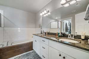 Bathroom featuring tile patterned flooring, separate shower and tub, vanity, and backsplash