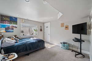 Carpeted bedroom featuring a textured ceiling