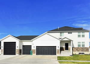 View of front of house featuring a garage and a front lawn