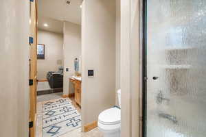 Bathroom featuring vanity, toilet, an enclosed shower, and tile patterned floors