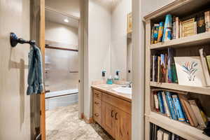 Bathroom featuring vanity and combined bath / shower with glass door