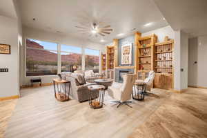 Living room featuring light wood-type flooring, a mountain view, and ceiling fan