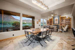 Dining space with ceiling fan, a mountain view, and a raised ceiling