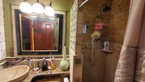 Bathroom featuring vanity and tile shower