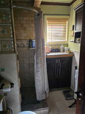 Bathroom featuring toilet, a shower with shower curtain, vanity, and tile walls