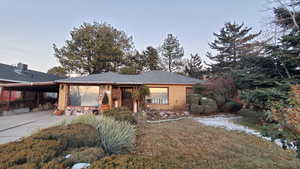 View of front of property featuring a carport and a front lawn