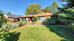 Ranch-style home featuring a front lawn