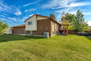 Back of home with deck and Bullfrog spa