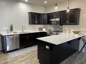 Kitchen featuring new quartz countertop, new pendant lights, a new sink, and stainless steel appliances.