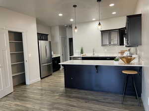 Kitchen with two pantries, a breakfast bar area, sink, stainless steel appliances, and kitchen peninsula.