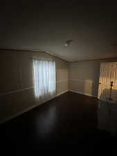 Spare room with vaulted ceiling and wood-type flooring