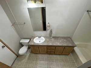 Bathroom with a tub, toilet, and vanity