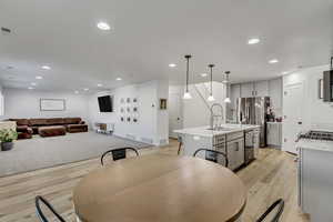 Dining room with sink and light wood-type flooring