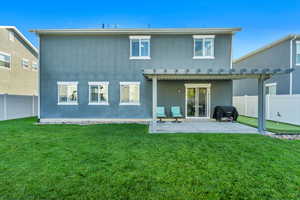 Back of house with a lawn and a patio area