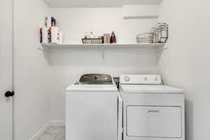 Laundry room featuring washing machine and dryer and light tile patterned floors