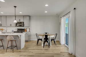 Kitchen featuring stainless steel appliances, light hardwood / wood-style flooring, sink, and gray cabinetry