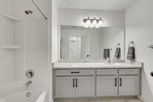 Bathroom with tile patterned flooring, shower / tub combo with curtain, and vanity