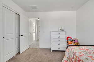 Carpeted bedroom with a closet