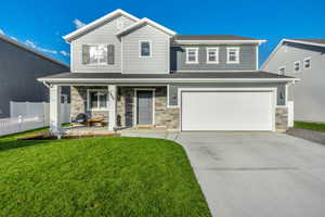 View of front of house with a garage, a front lawn, and a porch