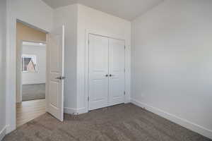 Unfurnished bedroom featuring a closet and carpet flooring