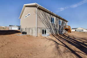 Back of property featuring central AC unit and a garage