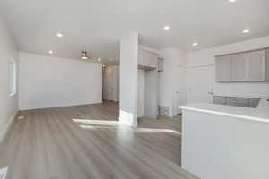Kitchen featuring ceiling fan, gray cabinets, and light hardwood / wood-style flooring